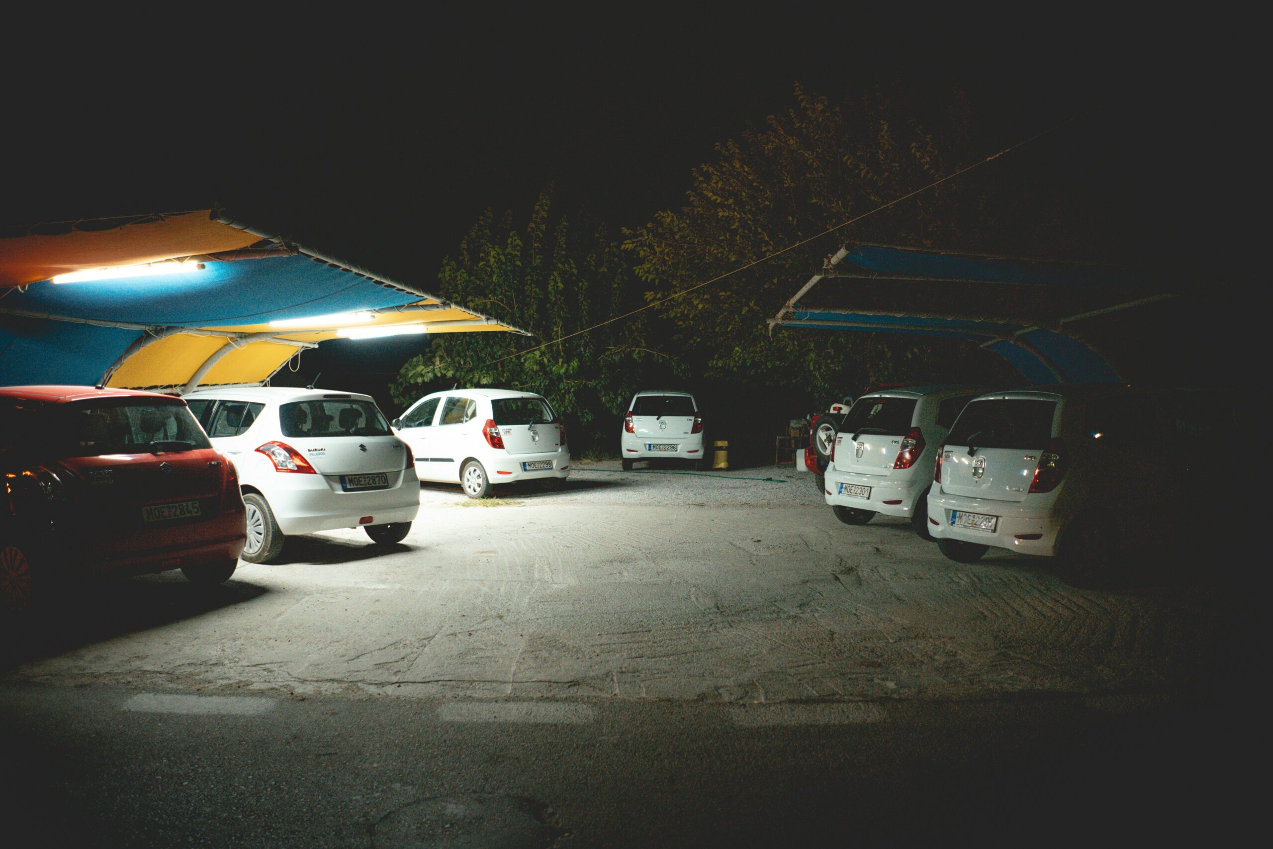 several vehicles parked beside sheds